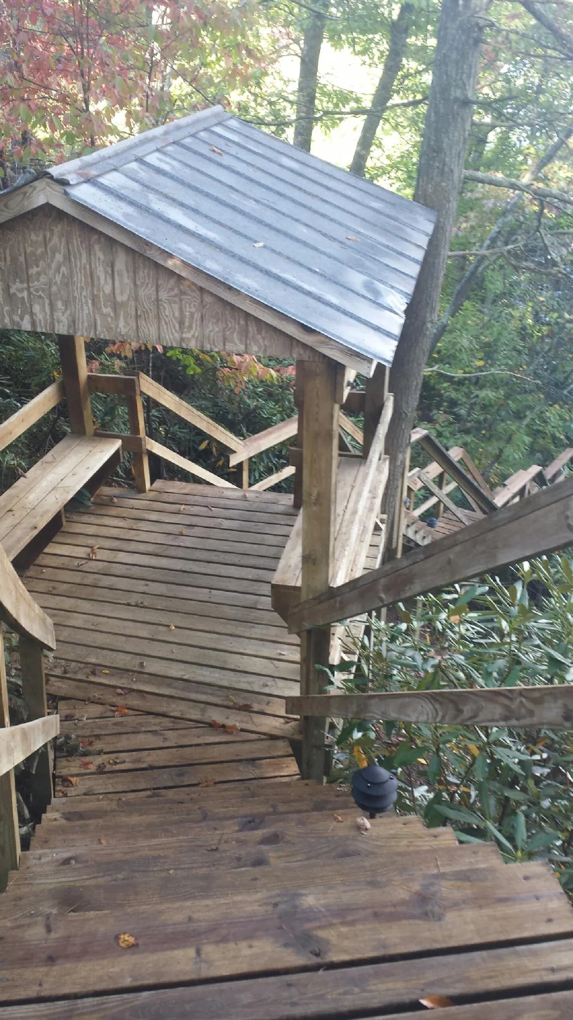 Metal roofed shelter over wooden steps on a wooded walkway — Skylight Repair & Installation work by our crew in South Sterling